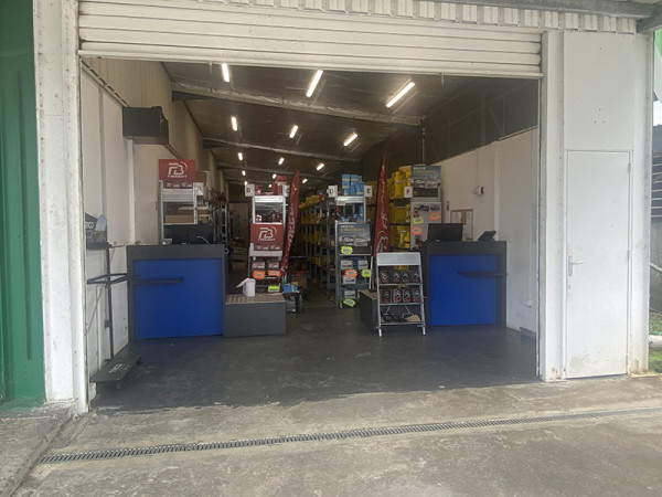 Intérieur de l’agence SACI Sainte-Rose avec comptoir d’accueil et pièces automobiles